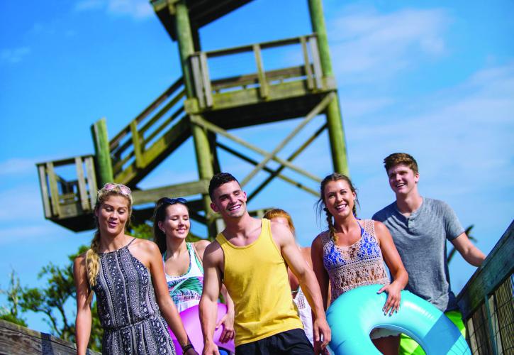 Visitors with Tubes walking down a boardwalk